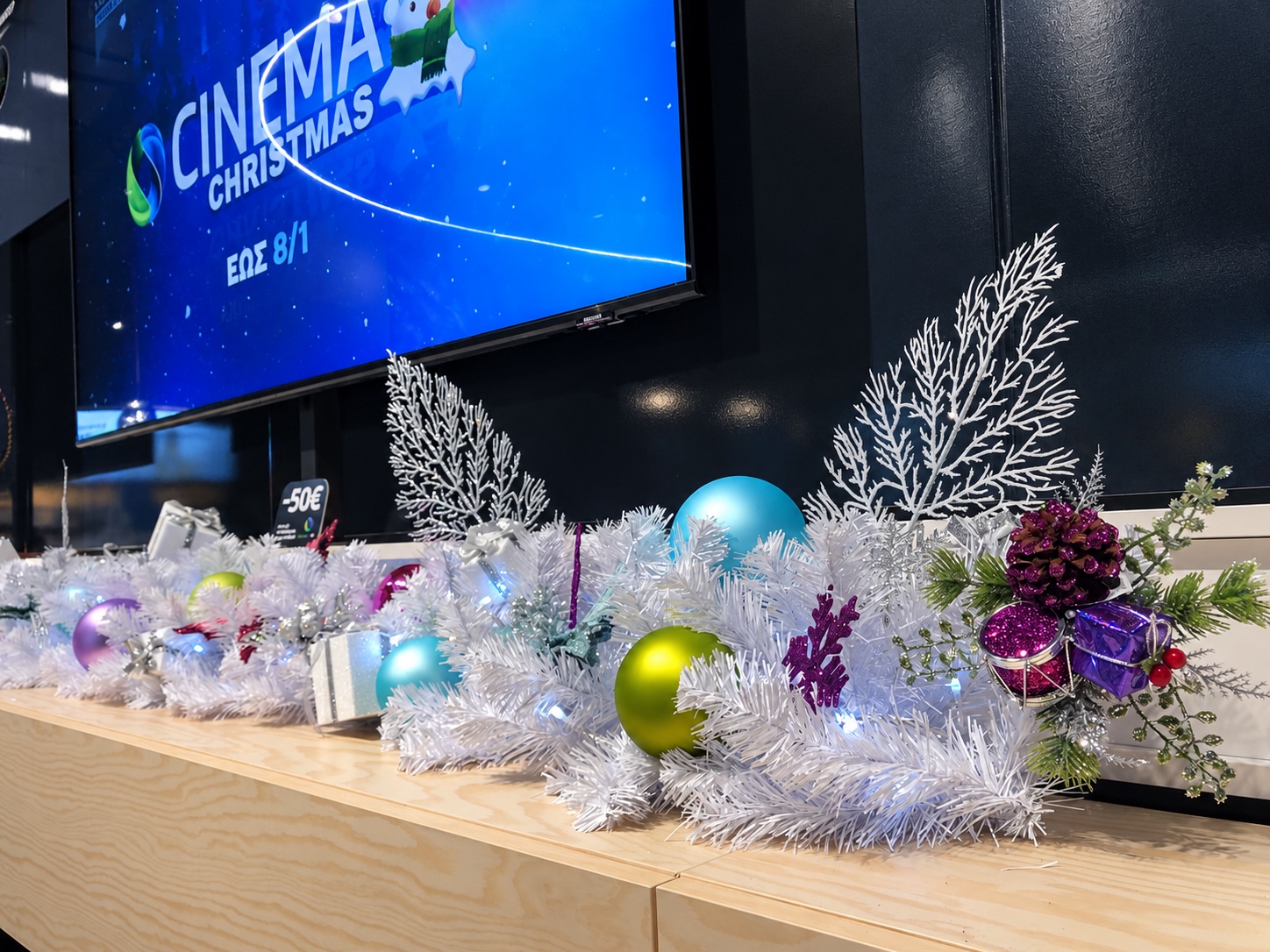 Festive white garland installation inside a COSMOTE store