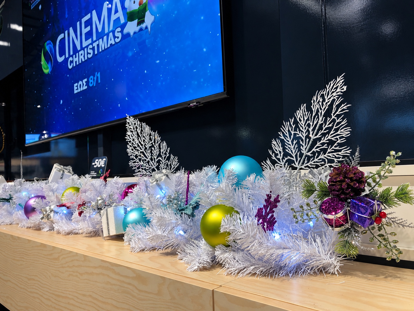 White Christmas garland and ornaments installed along a store counter