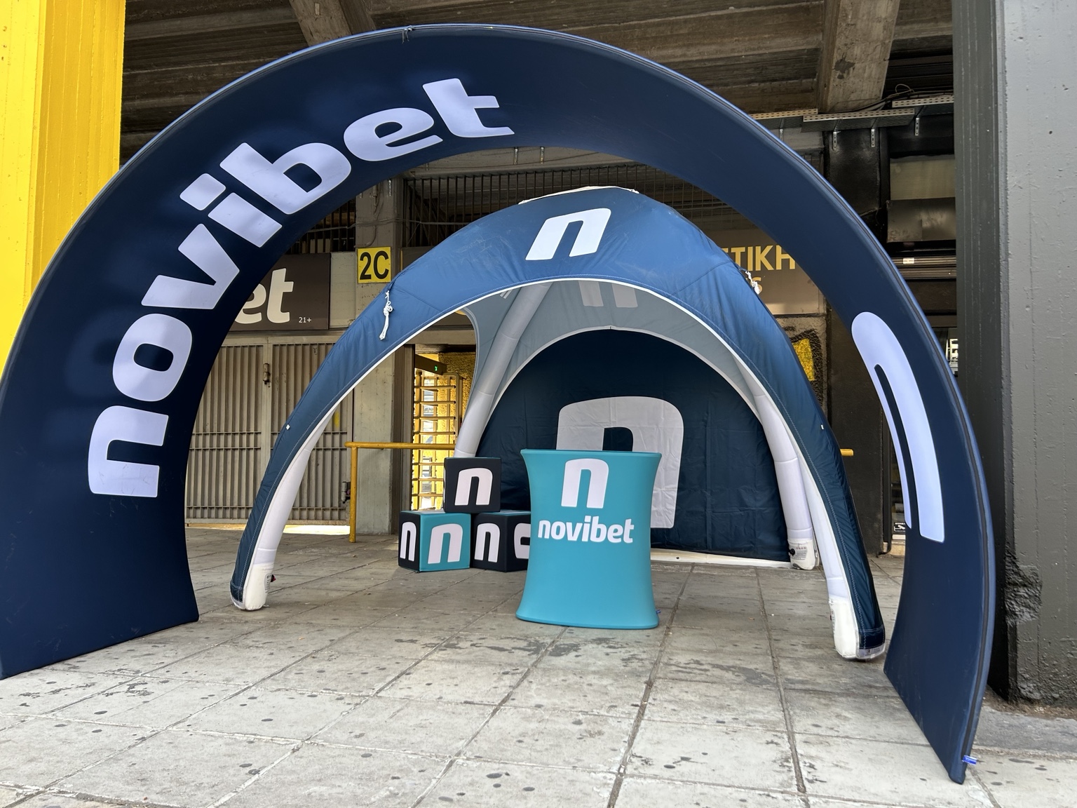 Novibet branded arch, tent and activation props set up at a stadium
