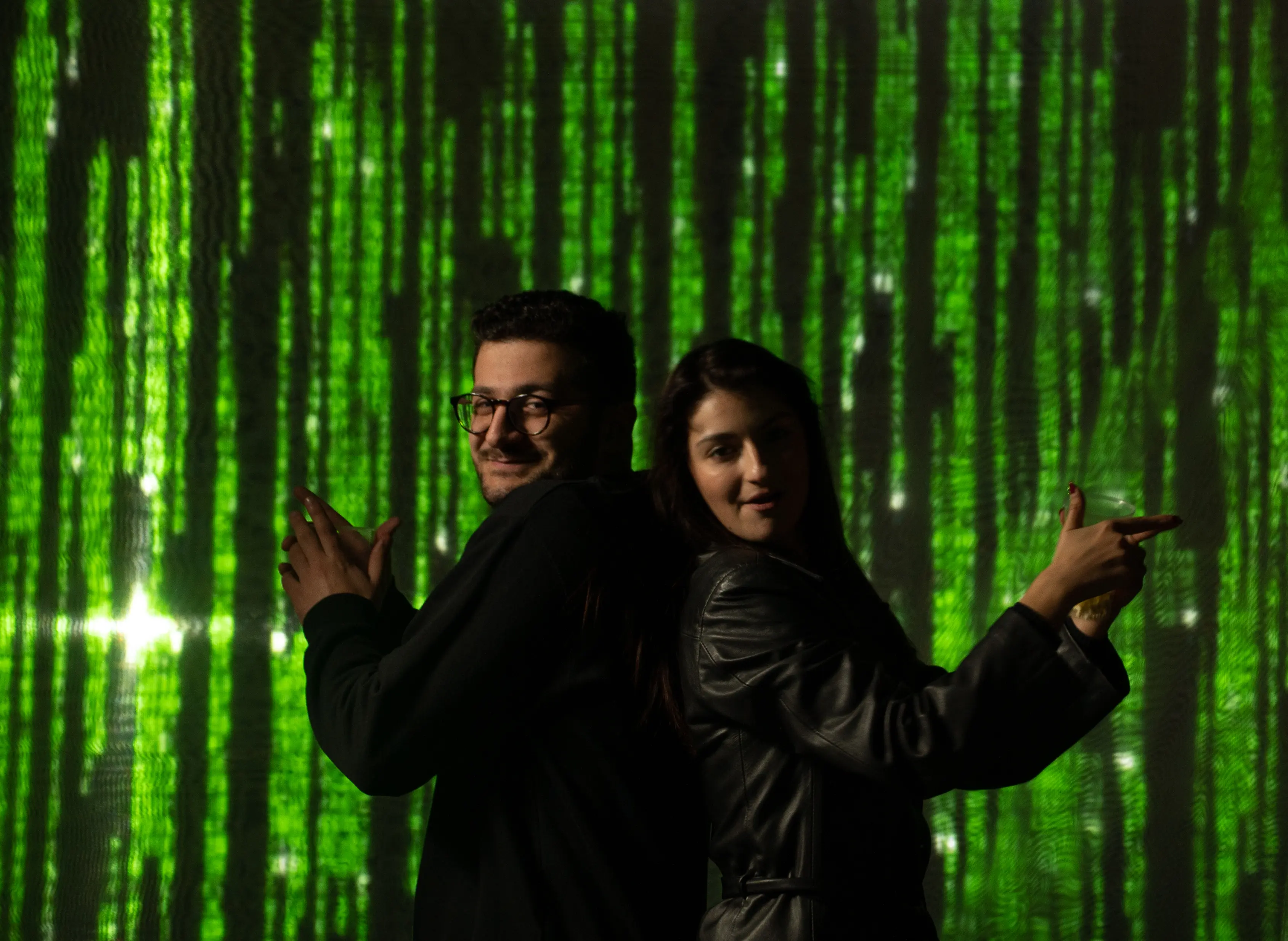 Guests posing against the Matrix code screen